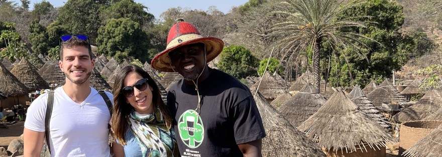 Viajeros con el guía al fondo la aldea tradicional y el paisaje