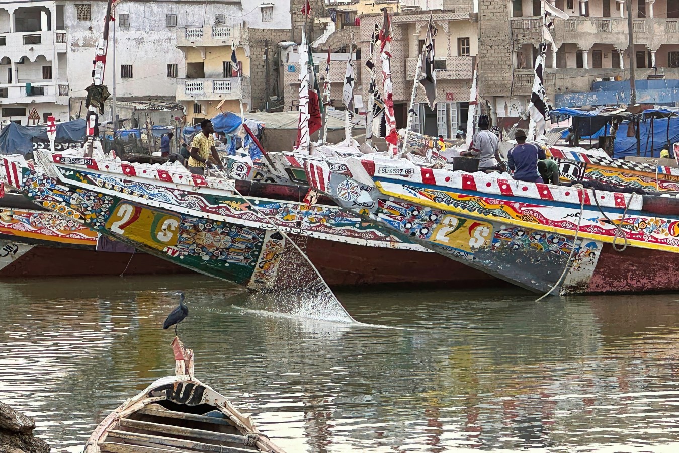 Puerto de la ciudad de Saint Louis, Senegal, barcos tradicionales y al fondo las casas