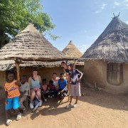 Casas típicas páis bedick muros de arcilla y techos de paja cónicos, los viajeros sentandos en su entrada con niños locales