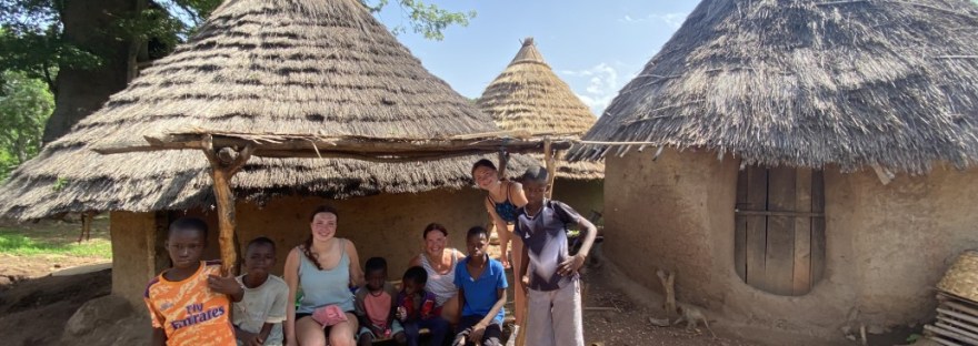 Casas típicas páis bedick muros de arcilla y techos de paja cónicos, los viajeros sentandos en su entrada con niños locales