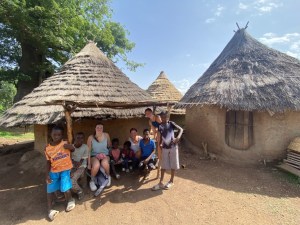 Casas típicas páis bedick muros de arcilla y techos de paja cónicos, los viajeros sentandos en su entrada con niños locales